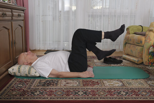 Old man making exercises in his living room - LAF000377