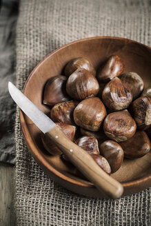 Chestnuts in wooden bowl, knife on top - SBDF000388