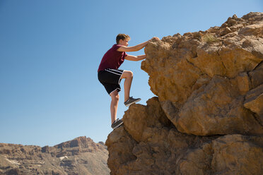 Spain, Canary Islands, Tenerife, Teide National Park, boy climbing on rock - WGF000245