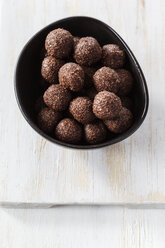 Bowl of coco chocolate truffles on white wooden table, studio shot - EVGF000301