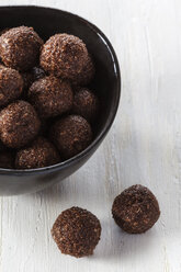 Bowl of coco chocolate truffles on white wooden table, studio shot - EVGF000302