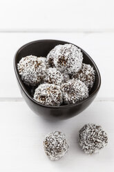 Bowl of coco chocolate truffles on white wooden table, studio shot - EVGF000303