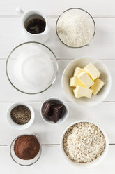 Bowls of ingredients for coco chocolate truffles on white wooden table, studio shot - EVGF000309