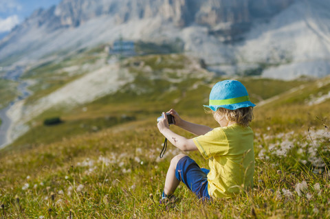 Italy, Province of Belluno, Veneto, Auronzo di Cadore, little boy photographing view near Tre Cime di Lavaredo stock photo