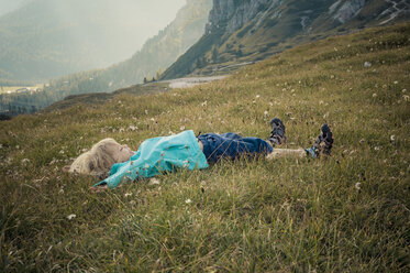 Italy, Province of Belluno, Veneto, Auronzo di Cadore, little boy lying on alpine meadow near Tre Cime di Lavaredo - MJF000468