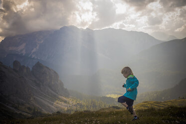 Italy, Province of Belluno, Veneto, Auronzo di Cadore, little boy running on alpine meadow near Tre Cime di Lavaredo - MJF000470