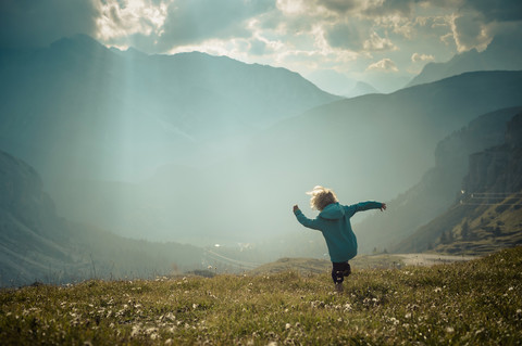 Italy, Province of Belluno, Veneto, Auronzo di Cadore, little boy walking on alpine meadow near Tre Cime di Lavaredo stock photo