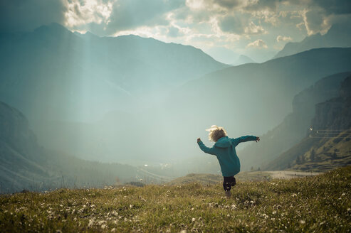 Italy, Province of Belluno, Veneto, Auronzo di Cadore, little boy walking on alpine meadow near Tre Cime di Lavaredo - MJF000472
