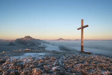 Deutschland, Baden-Württemberg, Landkreis Konstanz, Gipfelkreuz, Wintermorgen im Hegau mit Mögdeberg links und Hohenhewen am Horizont - ELF000756