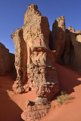 Algerien, Sahara, Tassili N'Ajjer Nationalpark, Tassili Tadrart, Frau beim Wandern in der felsigen Landschaft des Kars - ES000870