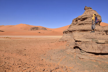 Algeria, Sahara, Tassili N'Ajjer National Park, Woman standing on rock in Tin Merzouga - ES000889