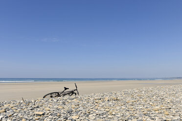 France, Bretagne, Finistere, bicycle at beach - LA000458