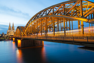 Deutschland, Nordrhein-Westfalen, Köln, Blick auf den Kölner Dom und die Hohenzollernbrücke in der Abenddämmerung - WGF000217