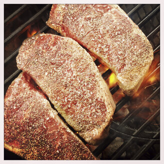Steaks aus der Rinderlende, gegrillt über heißem Holzkohlefeuer auf dem Grillrost - ABAF001147