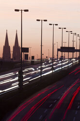 Germany, North Rhine-Westphalia, Cologne Cathedral and road traffic on lighted Zoobruecke at dusk - JATF000522