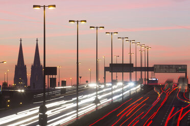 Germany, North Rhine-Westphalia, Cologne Cathedral and road traffic on lighted Zoobruecke at dusk - JATF000523