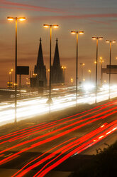 Deutschland, Nordrhein-Westfalen, Kölner Dom und Straßenverkehr auf der beleuchteten Zoobrücke in der Abenddämmerung - JAT000525