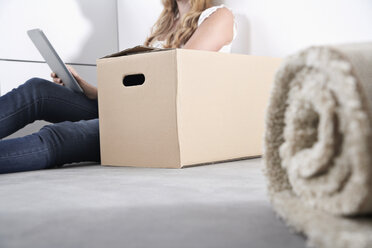 Young woman with cardboard box and tablet computer - PDF000602