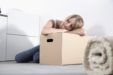 Young woman leaning on cardboard box - PDF000601