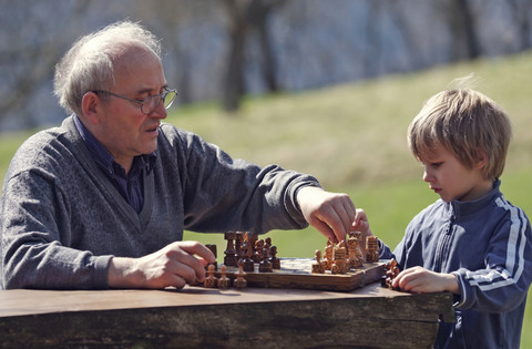 Deutschland, Rheinland-Pfalz, Leutesdorf, Großvater und Enkel spielen Schach, lizenzfreies Stockfoto