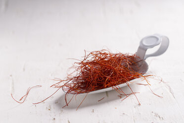 Chilifäden (Capsicum)l auf Löffel und Holztisch - MYF000092
