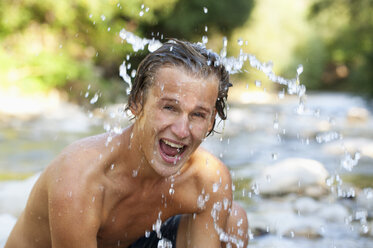 Austria, Salzkammergut, Mondsee, portrait of young man refeshing in a brook - WWF003196