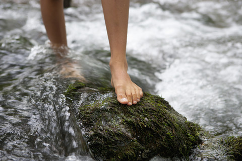 Austria, Salzkammergut, Mondsee, feet of teenage girl crossing a brook stock photo