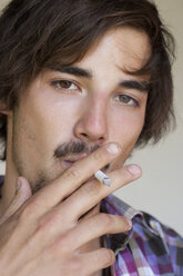 Porträt eines rauchenden jungen Mannes - WWF003164