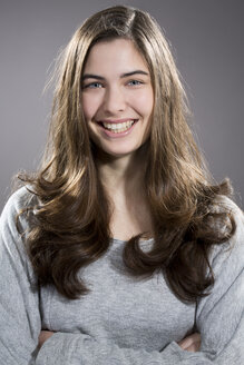 Porträt einer lächelnden jungen Frau, Studioaufnahme - MAEF007612