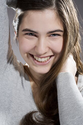 Portrait of smiling young woman, studio shot - MAEF007615