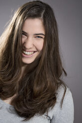 Portrait of smiling young woman, studio shot - MAEF007619