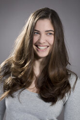 Portrait of smiling young woman, studio shot - MAEF007621