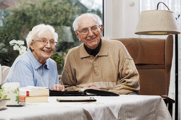 Älteres Ehepaar betrachtet alte Fotos zu Hause - BIF000282