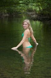 Österreich, Salzkammergut, Mondsee, junge Frau beim Baden in einem Bach - WWF003184