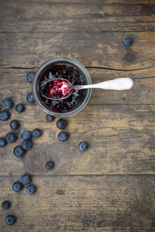 Heidelbeeren (Vaccinium myrtillus) und Glas Heidelbeermarmelade mit Löffel auf Holztisch - LVF000429