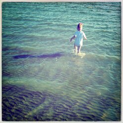 Mädchen läuft im Schlamm ins Meer, Nordsee, Föhr, Schleswig-Holstein, Deutschland - GSF000630