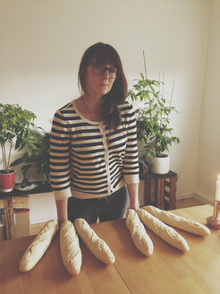 Young woman standing behind table with bread fingers, Picasso parody, Duesseldorf, NRW, Germany - MFF000709