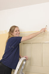 Young woman painting her apartment - LAF000412