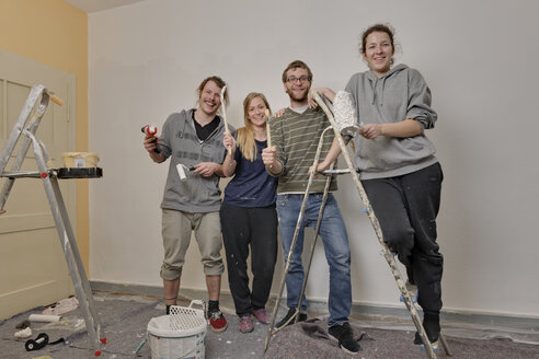 Gruppenbild von vier Freunden, die gemeinsam eine Wohnung renovieren - LAF000416