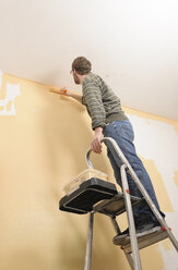 Young man painting apartment - LAF000410