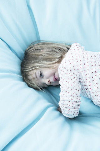 Little girl on light blue beanbag stock photo