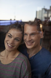 Portrait of smiling couple behind window - RBF001539