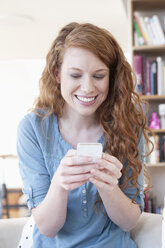 Young woman using smartphone at home - RBF001574