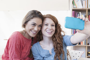 Zwei junge Freundinnen fotografieren sich selbst mit dem Smartphone - RBF001575