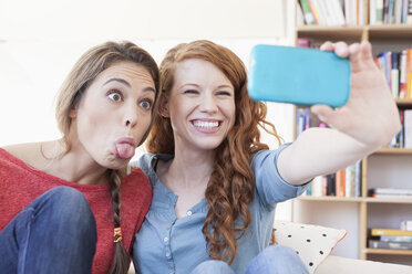 Two young female friends taking a picture of themseves with smartphone - RBF001576