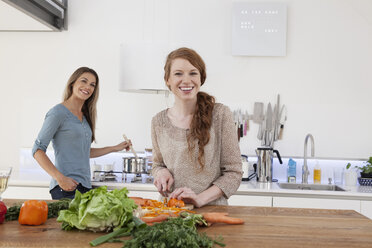 Zwei junge Freundinnen kochen zusammen - RBF001524