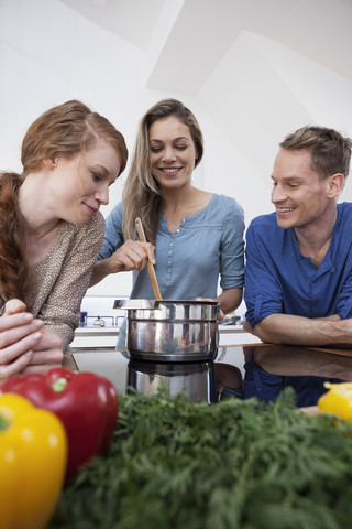 Drei Freunde kochen zusammen, lizenzfreies Stockfoto