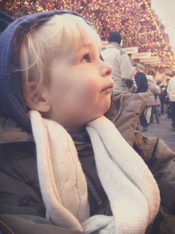 Aufgeregtes Kind, das zur Weihnachtsbeleuchtung hinaufschaut, Bonn, Nordrhein-Westfalen, Deutschland, lizenzfreies Stockfoto