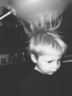 Little boy's hair being pulled up by static powers of balloon - MEAF000102