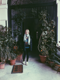 Junge Frau steht auf einem Balkon mit Pflanzen, Palermo, Sizilien, Italien - MEAF000106